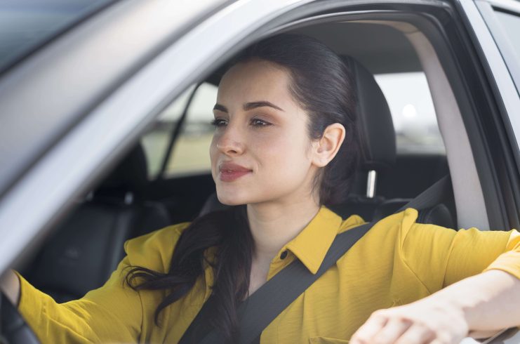 Mulher dirigindo de forma segura no trânsito, representando o maio amarelo.