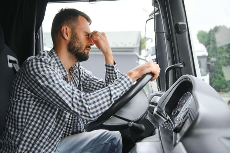 Motorista com o veículo parado esperando para realizar uma entrega.