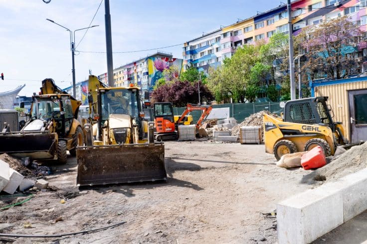 Máquinas e equipamentos parados em canteiro urbano, ilustrando um cenário de ociosidade em obras com ativos disponíveis fora de operação.