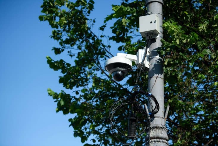 Câmera de vigilância em poste monitora fiação e ajuda a prevenir furto de cabos em área urbana